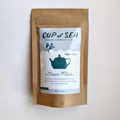 Stand-up pouch of tea featuring an illustration of a kettle with steam in the shape of seaweed. Label text says Cup of Sea, Maine seaweed teas, caffeine-free, Ocean Mint. Refreshing, energizing peppermint with a calm kelp undercurrent. Get your motor running while feeling anchored. Loose-leaf. Net weight 1.5 ounces, 43 grams.
